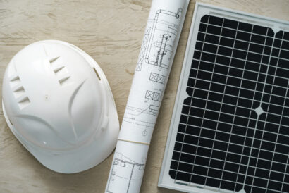 Blueprint roll and solar panel, home project close up