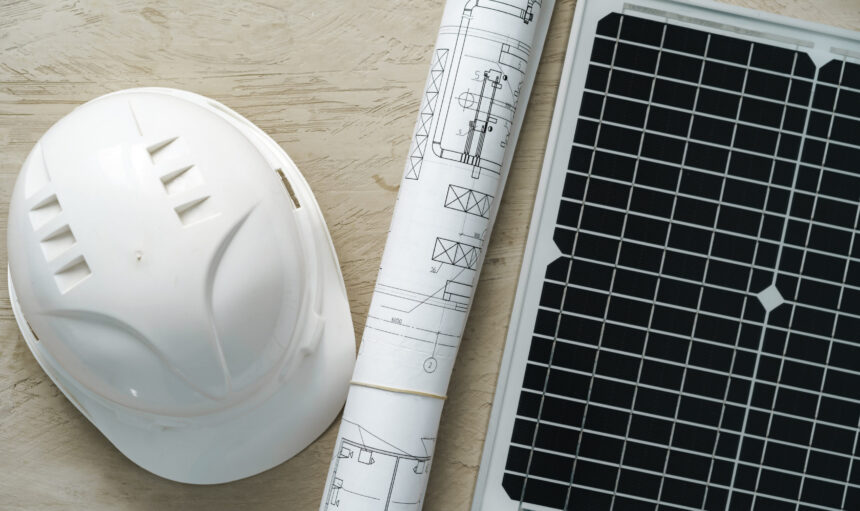 Blueprint roll and solar panel, home project close up