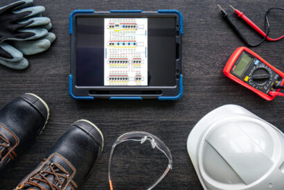 Composition with digital tablet and electrician work items, top view.